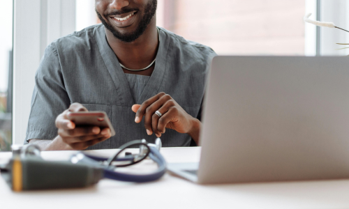 clinical staff member smiling whilst using a smart phone