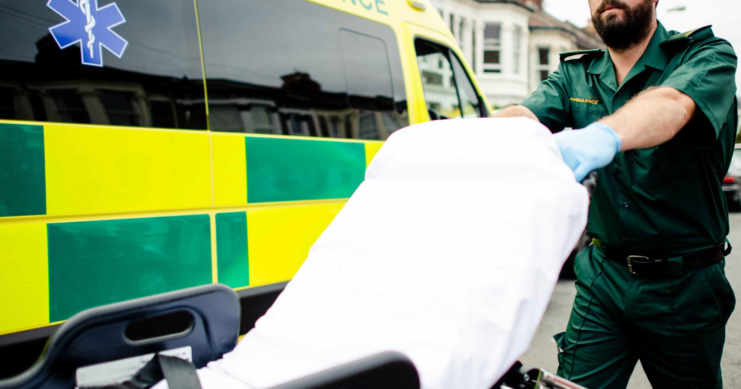 male paramedic moving ambulance stretcher